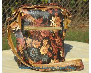 Faux leather crossbody travel bag with muted fall foliage print. 1 zipper pocket.  Goldtone and Copper accents. Fully lined, 1 slip pocket.